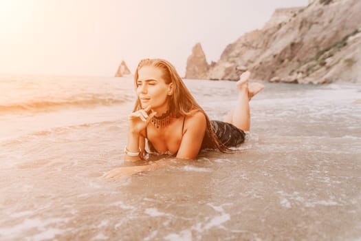 Woman travel sea. Young Happy woman in a long red dress posing on a beach near the sea on background of volcanic rocks, like in Iceland, sharing travel adventure journey