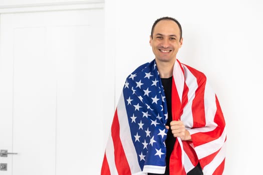 Handsome man with USA flag on light background. Memorial Day celebration. High quality photo