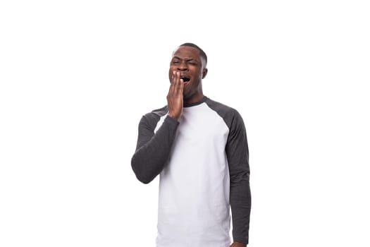 young positive african man dressed in a spring jacket on a white background with copy space.