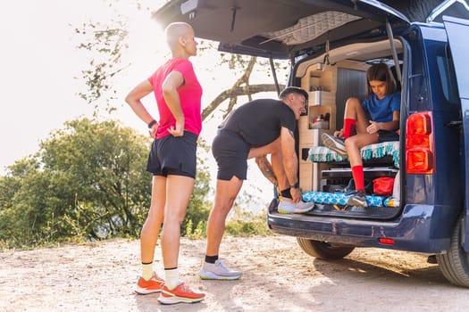 family in their camper van preparing to trail running and do sports in nature, concept of family outdoor activities and healthy lifestyle, copy space for text