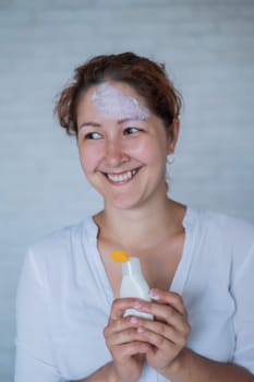 Portrait of a Caucasian woman with vitiligo diseas uses sunscreen.