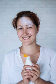 Portrait of a Caucasian woman with vitiligo diseas uses sunscreen.