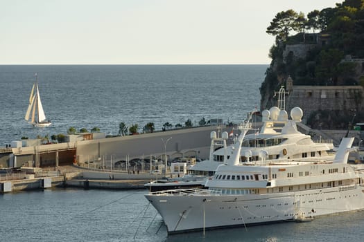 Monaco, Monte Carlo, 23 October 2022: Vintage sailing boat Tuiga 1909 going to the port Hercules, the team prepares the boat, pier and mega yacht. High quality photo