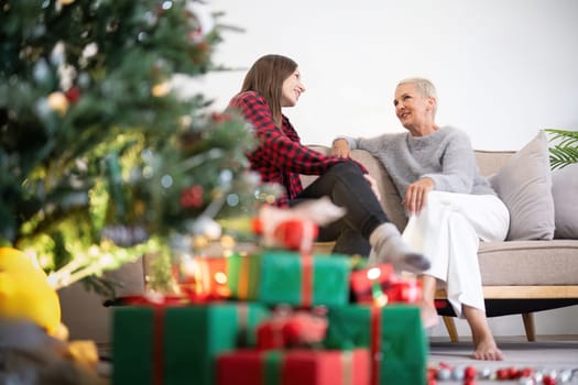 Senior woman with adult daughter enjoying time at home on Christmas eve.