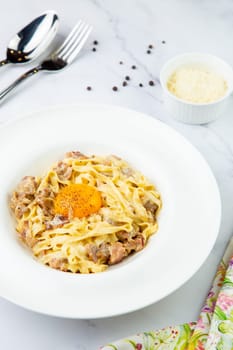 pasta in cream sauce with egg and black pepper on top