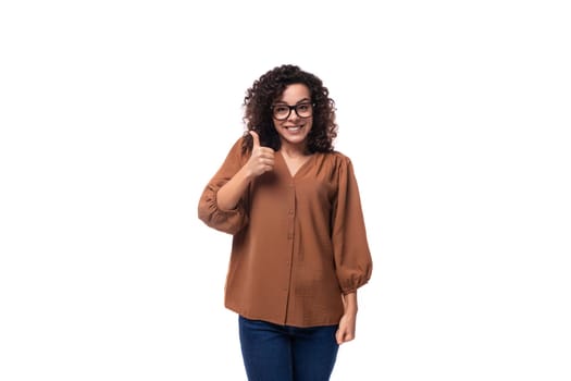 young cheerful european curly woman with black hair dressed in blouse isolated on white background with copy space.