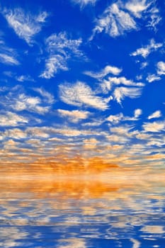 Wispy Clouds in the Sky. White clouds over a blue sky reflected in calm waters
