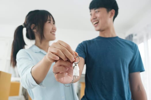 Happy young couple buying a new house receiving the keys. House owner real estate concept.