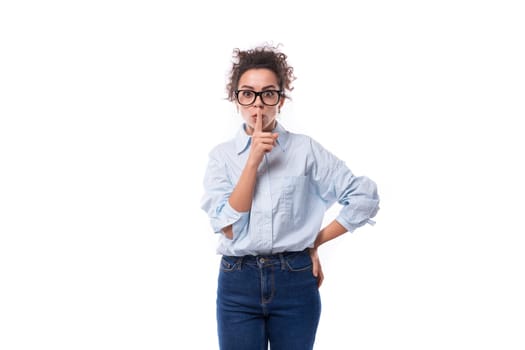 portrait of a young smiling fashionista caucasian woman working in the office who puts on glasses and a light blue shirt.