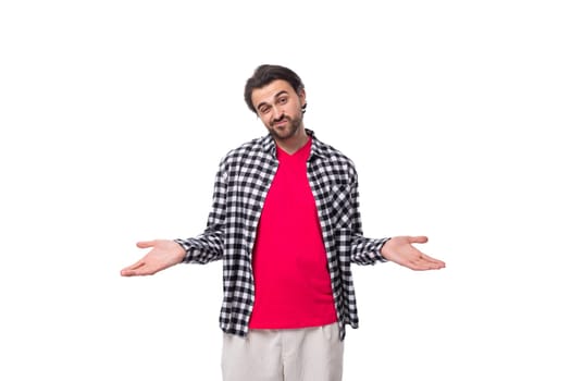 young smart brunette caucasian man with a beard in a plaid shirt on a white background.