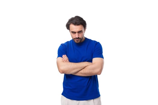 young brunette man with a beard dressed in a blue t-shirt thinks about a strategy and an idea on a white background.