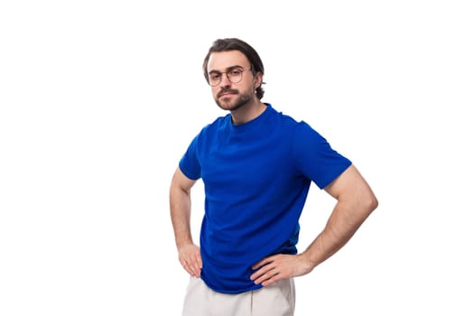 young surprised confident caucasian brunette man with a beard and glasses in a blue t-shirt on a white background.