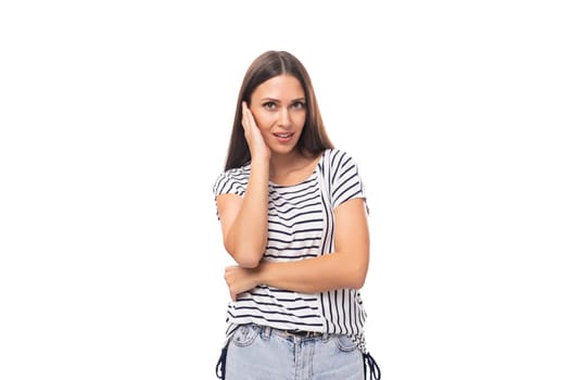 30 year old pretty brunette model woman with long straight hair dressed in a striped t-shirt on a white background with copy space.