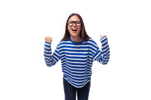 young stylish brunette lady in a striped blue sweatshirt reports news and advertising on a white background with copy space. advertising concept.