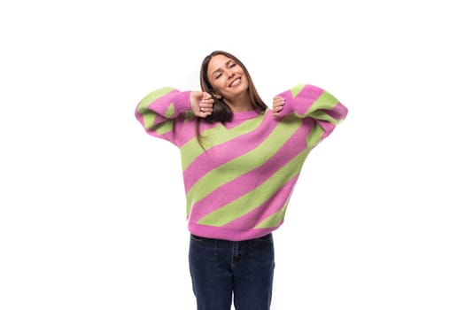 young cheerful charming caucasian woman with straight black hair is dressed in a stylish autumn striped sweater.