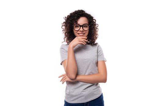 well-groomed cheerful energetic young european slim brunette woman with curly hair styling on a white background with copy space.