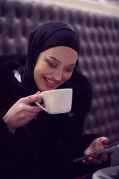Arabic women with abaya bonding and having fun outdoors - Happy Middle Eastern female having a break take a cup of tea in restaurant