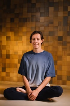 a man in a sports uniform does yoga in a fitness room. the concept of a healthy lifestyle.