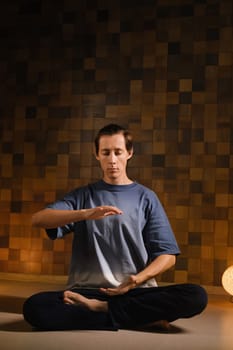 a man in a sports uniform does yoga in a fitness room. the concept of a healthy lifestyle.