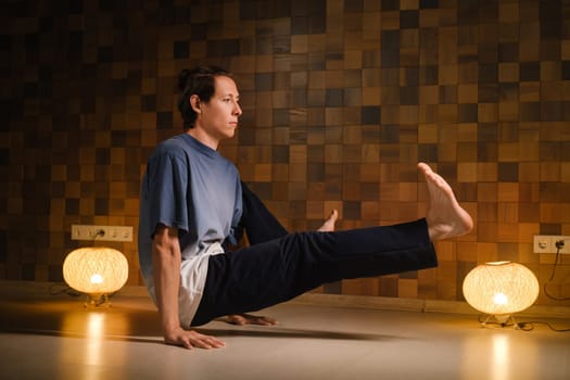 a man with a naked torso does yoga in the gym. the concept of a healthy lifestyle.