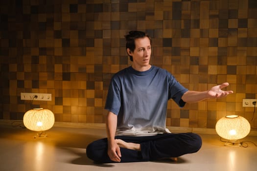 a man in a sports uniform does yoga in a fitness room. the concept of a healthy lifestyle.