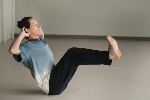 a man in a sports uniform does yoga in a fitness room. the concept of a healthy lifestyle.