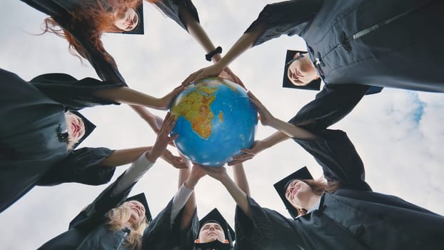 Graduating students embrace a geographical globe of the world. The concept of preserving peace.