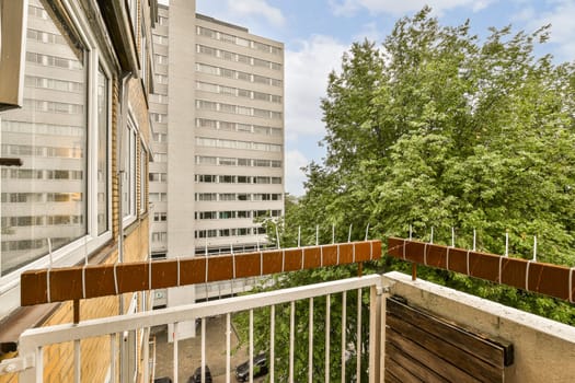 a balcony with trees and buildings in the background, taken from an apartment window looking out to the city below