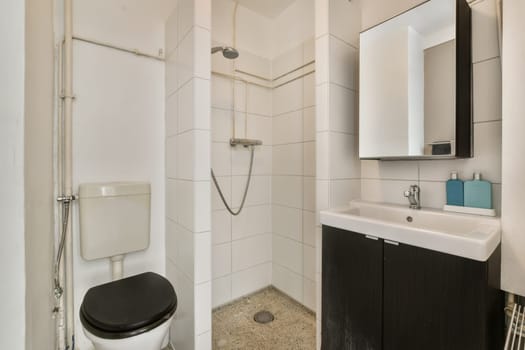 a modern bathroom with black and white tiles on the floor, sink, toilet, mirror and shower stall door