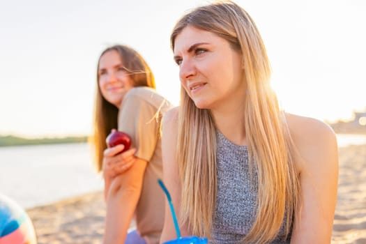 Two young beautiful women are having fun on beach and smiling. Have a carefree time with friends