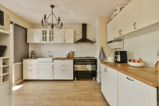 a kitchen with white cabinets and wood counter tops on the island in front of the sink is an old fashioned stove