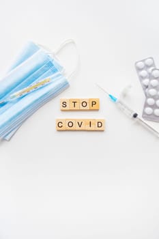 Stop coronavirus inscription. A new strain of coronavirus-omicron, pyrola. Preparing for vaccination against covid. Syringe, vaccine, pills, medical mask