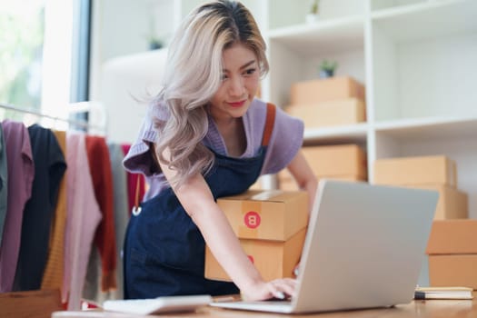 Asian female business owner handles delivery of orders to customers.