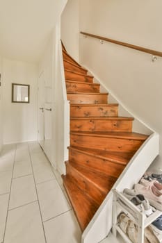 a wooden staircase in a white room with tile flooring and wood steps leading up to the second floor area
