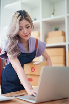 Asian female business owner handles delivery of orders to customers.