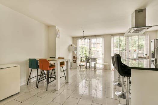 a kitchen and dining area in a house with white tiles on the floor, walls, floors and ceilings