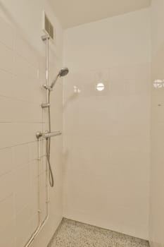 a bathroom with white tiles on the walls and shower head mounted to the wall in front of the bathtub