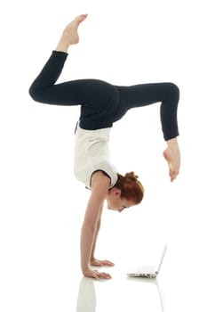 Concept of multitasking. Girl doing handstand with laptop