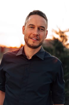 Portrait of handsome successful man standing outdoors close up