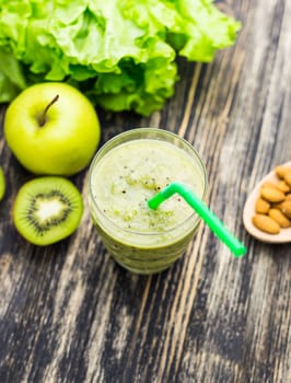 Healthy green smoothie with kiwi, apple on rustic wood background