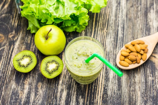 Healthy green smoothie with kiwi, apple on rustic wood background