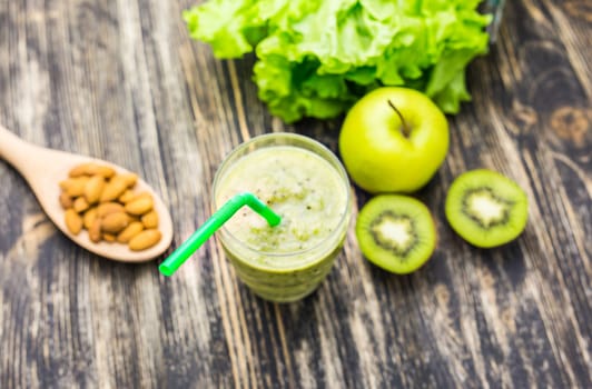 Healthy green smoothie with kiwi, apple on rustic wood background