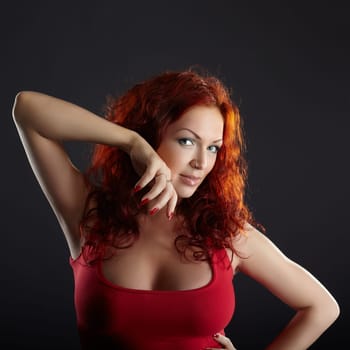 Seductive red-haired woman posing on gray background