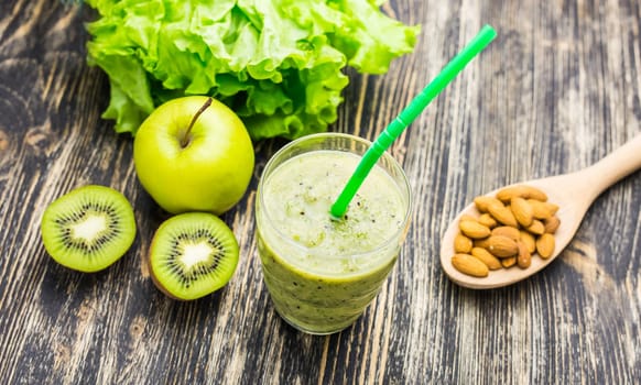 Healthy green smoothie with kiwi, apple on rustic wood background