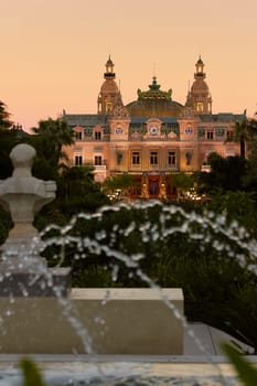 Monaco, Monte-Carlo, 21 October 2022: Square Casino Monte-Carlo at sunny day, a lot of luxury cars, Hotel de Paris, wealth life, tourists take pictures of the landmark, pine trees, blue sky, flowers. High quality 4k footage