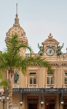 Monaco, Monte-Carlo, 21 October 2022: Facade of Casino Monte-Carlo at sunny day, wealth life, famous landmark, pine trees, blue sky. High quality photo