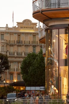 Monaco, Monte-Carlo, 28 September 2022: Tourists and wealthy people visit branded shops near the hotel Paris and Casino Monte-Carlo, hotel Hermitage at sunset, luxury life. High quality photo