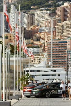 Monaco, Monte-Carlo, 29 September 2022: Exterior of new Yacht Club at sunny day, port Hercules, flagpoles, mega yachts and real estate on background. High quality photo