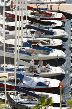 Monaco, Monte-Carlo, 29 September 2022: a lot of sail boats are moored in the new Yacht Club at sunny day, no wind, teams is waiting race, port Hercules, bow with sails. High quality photo