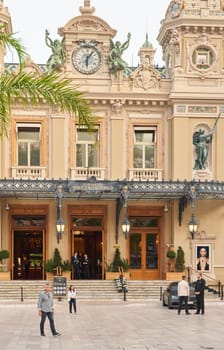 Monaco, Monte-Carlo, 21 October 2022: Square Casino Monte-Carlo at cloudy day, a lot of luxury cars, Hotel de Paris, wealth life, tourists take pictures of the landmark, pine trees, blue sky, flowers. High quality photo